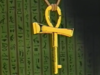 Gold ankh-shaped key with lace threated through its loop